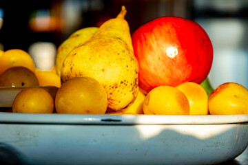 dish with pears, plums and apples