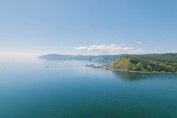 Obraz premium Lake Baikal is a marvelous blue jewel framed by scenic mountains and forests. Epic cinematic aerial view Lake Baikal. Aerial view of blue lake and green forests.