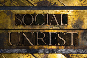 Social Unrest text on vintage textured grunge copper and gold background