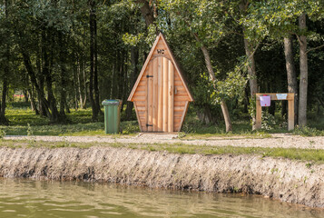 Wood WC in nature in summer. Outhouse latrine.