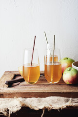 Organic apple cider in glasses with a straw.