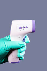 Remote digital thermometer in gloved hand