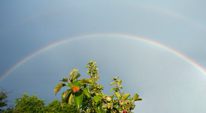 Rainbow arc on cloudy sky. High quality photo