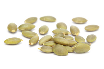 Micro close-up and details of Organic roasted green pumpkin seed (Cucurbita pepo)  isolated over white background.