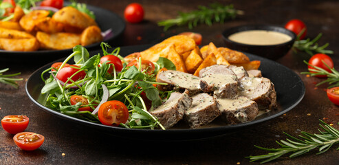 Roast Pork Tenderloin in mustard gravy with vegetables and potato wedges