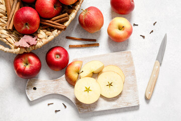 Naklejka na ściany i meble Fresh ripe red apples with knife and chopping board on white table background. Autumn apple flat lay, top view, copy space. Autumn harvest and cooking apple meal, apple pie concept.