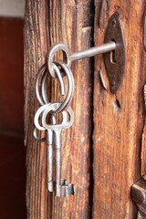 Obraz premium set of keys and antique plate on a wooden door from the early 20th century