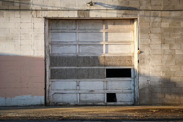 Old aged and rundown urban building with broken garage door