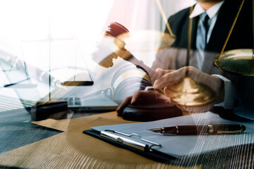 Business and lawyers discussing contract papers with brass scale on desk in office. Law, legal services, advice, justice and law concept picture with film grain effect