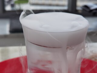 glass with overflowing white haze