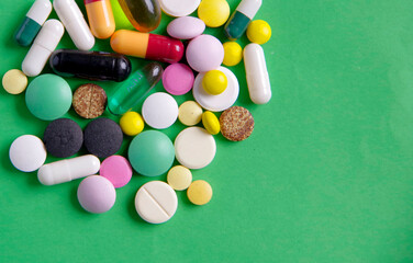 Medicines in the form of pills on a green background.