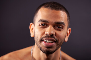 close up portrait of smiling young attractive black man isolated on studio black background