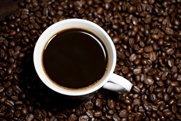 Coffee cup top view on roasted coffee beans background