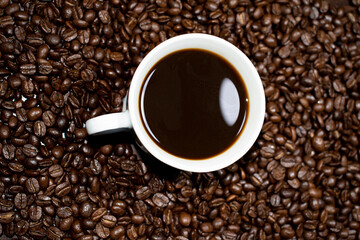 Coffee cup top view on roasted coffee beans background