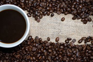 Roasted Coffee Beans on Burlap Canvas Background. Copy Space for Text.