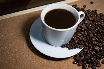 Coffee cup and saucer on a wooden table. Dark background.