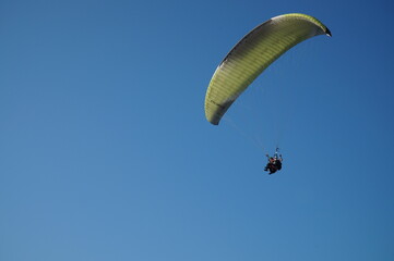 A paraglider flying thanks to the air currents. Extreme hobby.