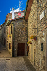 Italian medieval village details, historical stone alley, ancient marrow street, old city stone buildings architecture. Santa Fiora, Tuscany, Italy.