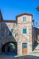 Italian medieval village details, historical stone arch, ancient gate, old city stone buildings architecture. Santa Fiora, Tuscany, Italy.