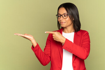 Confident african american businesswoman in red jacket point finger to open palm demonstrating object, new product or space for advertisement. Successful woman customer show hand advertising service