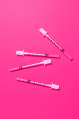 Lots of thin cosmetic syringes on pink background