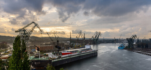 Gdańsk Shipyard - shipyard cranes over the Vistula river during the falling rain