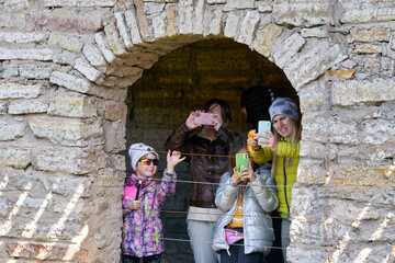 A family of tourists takes pictures of the landmark on a mobile phone