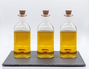 THREE EXTRA VIRGIN OLIVE OIL BOTTLE with SPAIN FLAG ON A BLACK SLATE PLATE