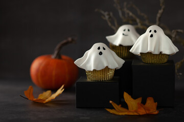 Halloween fondant ghost cupcakes on black podiums.  Halloween party food idea.