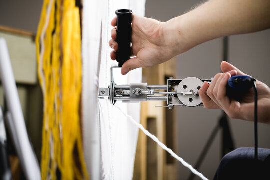 Cropped View Of Craftsman Using Tufting Gun Near Carpet On Canvas And Threads 