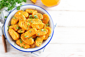 Gnocchi with a pumpkin on the plate. Italian dumplings with butter. Top view, copy space