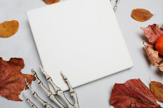 Wrapped canvas and Halloween decorations on grey background. Mockup poster. Autumn and Halloween concept.