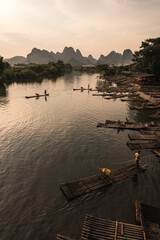 some fisherman on little boats on a river in the chinese mountains