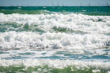 Waves of the Black Sea on a clear day. Fishing trap in the background.