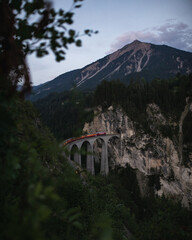 the landwasservidukt in the swiss mountains at sunset with a train on it