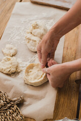 Close-up of female hands sculpt from dough. Bakery and pastry shop concept