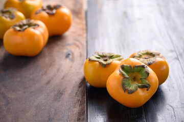 Ripe persimmon fruit on wooden background