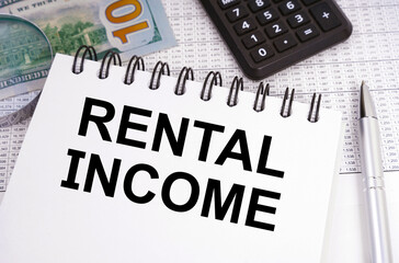 On the table there is money, a calculator and a notebook with the inscription - RENTAL INCOME