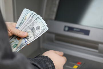 A man withdraws cash on the street at an ATM