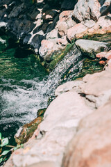 small waterfall flows through the stones 