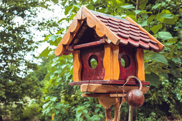 Brown, handmade wooden bird house in the backyard in countryside