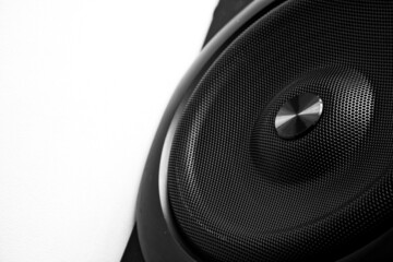 Black audio speaker with metal grille on a white background. Concept for audio technology, music,...