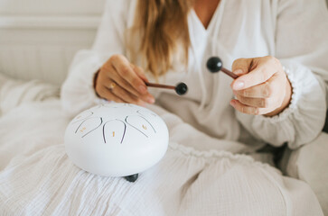 white drum glucophone and drum sticks on the lap of a young woman plus size model in white dress...
