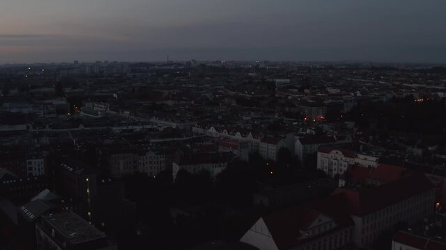 Slow forwards fly above urban neighbourhood. Aerial view of streets and buildings in city before sunrise. Berlin, Germany