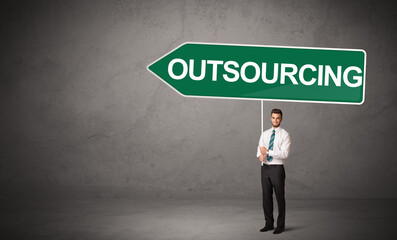 Obraz premium Young business person in casual holding road sign