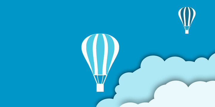 Hot air balloon with basket on the background of the sky and clouds.