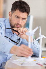 architect in office working on 3d windmill model