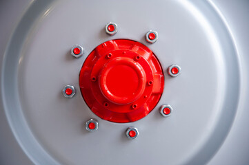 Close-up of industiral machine rim with screws and red hub