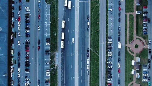 Flight over wide city street with long road and different cars passing by and multistoreyed highrise buildings aerial upper view