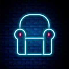 Glowing neon line Armchair icon isolated on brick wall background. Colorful outline concept. Vector